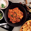 Bilde 1 av Tikka Masala med kylling og ris – en smakfull indisk rett med kylling i kremet tomatsaus, servert med ris.