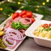 Bilde av et overdådig julefestbord med kald ribbe og rødkål, røkt og gravet laks med eggerøre og sennepssaus, mør juleskinke med waldorfsalat, saftig roastbiff med hjemmelaget potetsalat, kalkunbryst med appelsinkompott, luksuriøs skagenrøre med reker og kreps, edamerost og brie med sprø kjeks, samt assortert brød og smør. En smakfull julebuffet klar til servering.