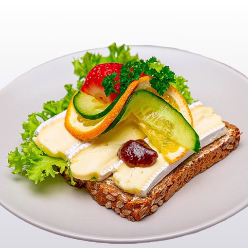 Bilde av et smørbrød med kremet brie, friske druer og fikenmarmelade.
