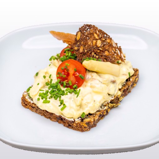 Bilde av dansk smørbrød med kremet hønsesalat, sprø stangselleri og knasende rugchips, servert på dansk rugbrød.