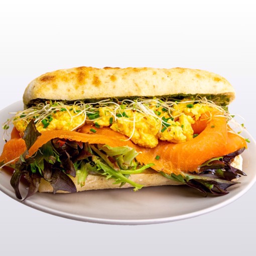 Bilde av focaccia med røkt laks, frisk ruccola og kremet urtedressing, servert i et gyllent og luftig brød.