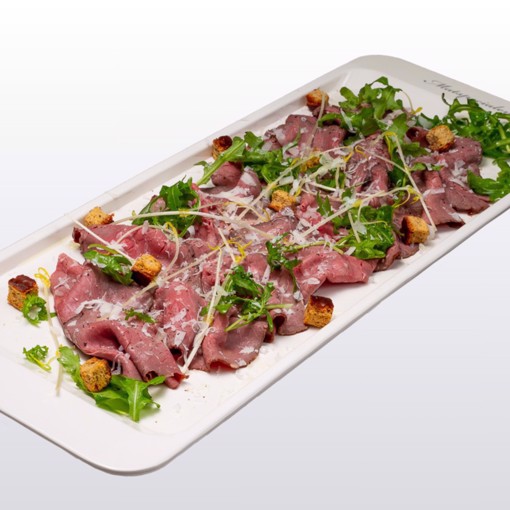 Bilde av mørt, hjemmelaget roastbiff i tynne skiver, toppet med revet parmesan, frisk salat og sprø brødkrutonger. Smaksatt med sitron og kvalitetsolivenolje for en balansert og elegant rett.