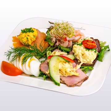 Bilde av Koldttallerken fra Matspecialen – en klassisk lunsjtallerken med egg og tomat, røkt laks med eggerøre, reker med majones og sitron, roastbiff med potetsalat og sprøstekt løk, pepperskinke med italiensk salat. Serveres med ferskt brød og smør for en komplett og smakfull måltidsopplevelse.