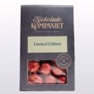 Glinsende drasjert lakriskaramell dekket i sjokolade med rødlig overflate, elegant presentert i pose – en fristende kombinasjon av lakris, sjokolade og et hint av jordbær.