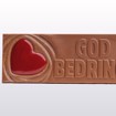 Bilde av en sjokoladeplate i melkesjokolade og karamellsjokolade med teksten "God bedring" preget på toppen. Ligger på lys bakgrunn og uttrykker omtanke og støtte på en varm og velsmakende måte.