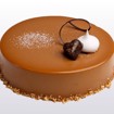 Sjokolademoussekake med karamellglasur, mørk sjokolademousse, karamellfyll og sprø bunn – pyntet med ristede hasselnøtter.