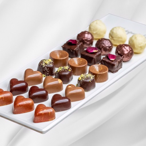 Bilde av et elegant konfektfat med et variert utvalg av håndlaget sjokolade og konfektbiter.