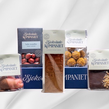 Julepakke gaveeske med sjokolade, marsipan og drasjerte mandler på hvit bakgrunn