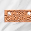 Sjokoladeplate med teksten Merry Christmas! i melk- og karamellsjokolade på hvit bakgrunn