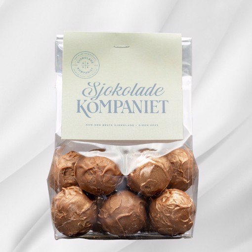 Bilde av Salt Karamell Lys sjokoladekuler fra Sjokoladekompaniet – kremet lys sjokolade fylt med søt og salt karamell. En harmonisk kombinasjon av fyldig sødme og en subtil salt undertone, perfekt for enhver anledning.