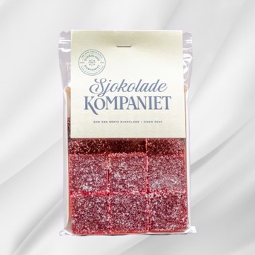 Bilde av Bringebærgele fra Sjokoladekompaniet – veganske biter av fruktig pâte de fruits laget med ekte bringebær. Frisk og balansert mellom sødme og syrlighet, skåret i små ruter for enkel nytelse.