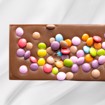 Bilde av Barnas Favoritt sjokoladeplate fra Sjokoladekompaniet, laget med en kombinasjon av myk melkesjokolade, søt karamellsjokolade og fargerike sjokoladelinser. En festlig og smakfull sjokoladeopplevelse som passer perfekt til bursdager og koselige stunder.