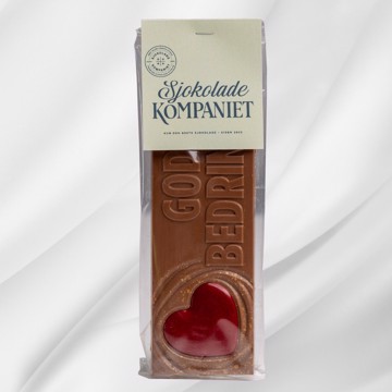 Bilde av en sjokoladeplate i melkesjokolade og karamellsjokolade med teksten God bedring! preget på toppen. Ligger på lys bakgrunn og uttrykker omtanke og støtte på en varm og velsmakende måte.